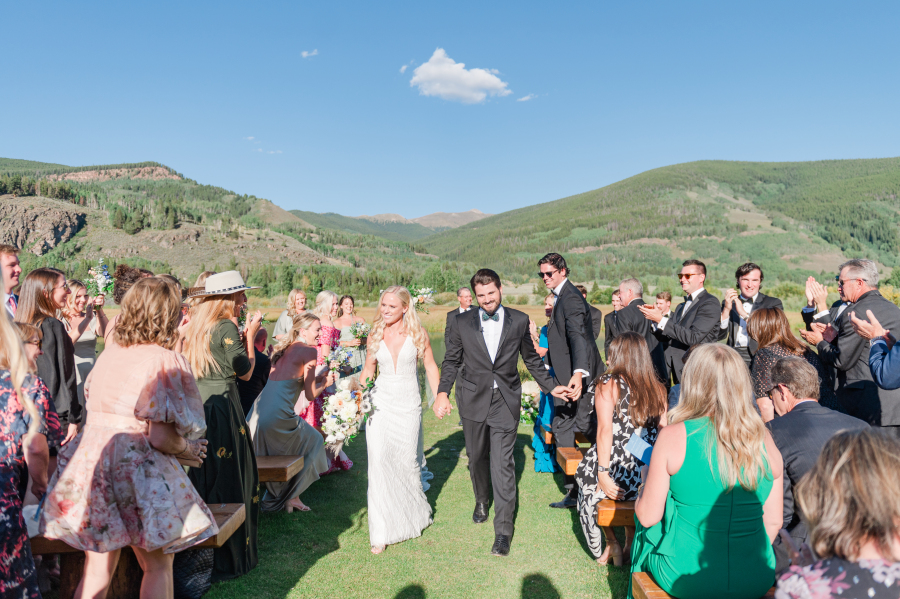 A bride and groom walk up the aisle after their outdoor camp hale weddings ceremony