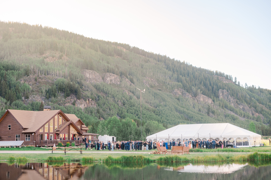 A look across the pond of the camp hale weddings venue during an outdoor cocktail hour