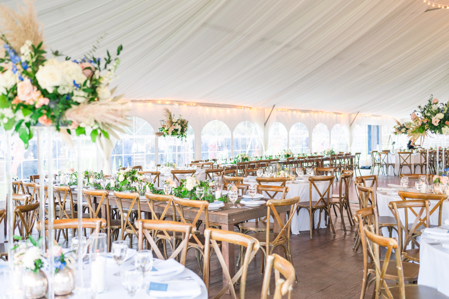 A look into the tent of one of the camp hale weddings receptions with wooden tables and chairs