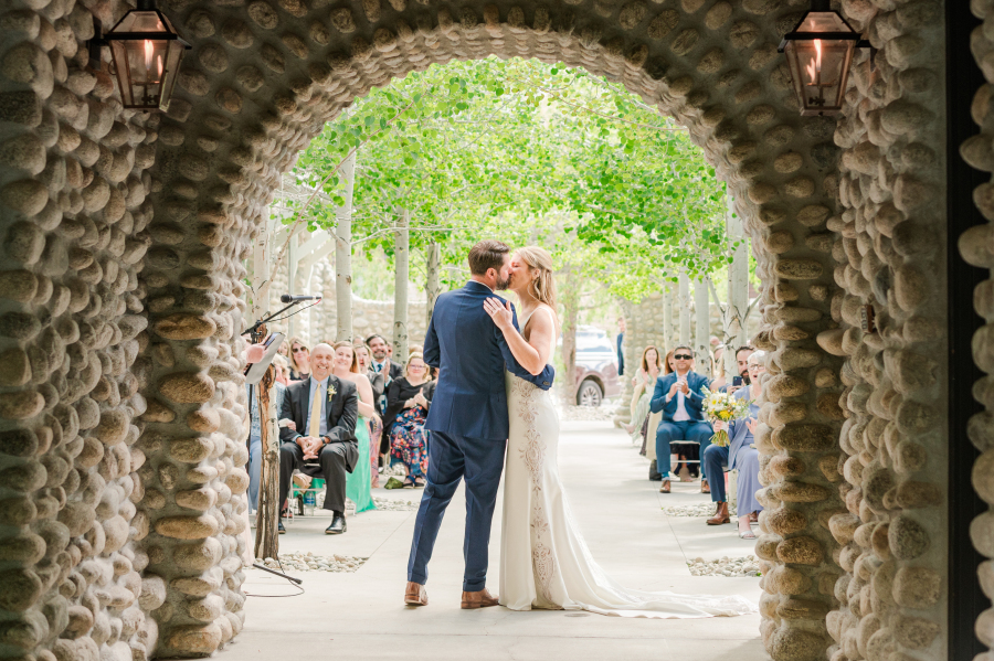 Newlyweds kiss to end their surf hotel wedding ceremony in a stone garden area