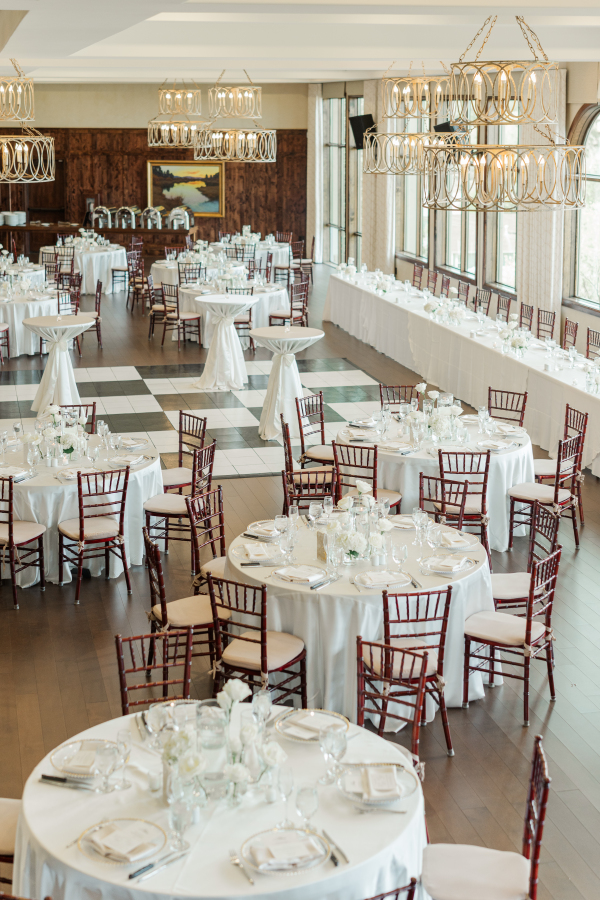 A look down into one of the Colorado Springs wedding venues with white round tables and unique modern chandeliers