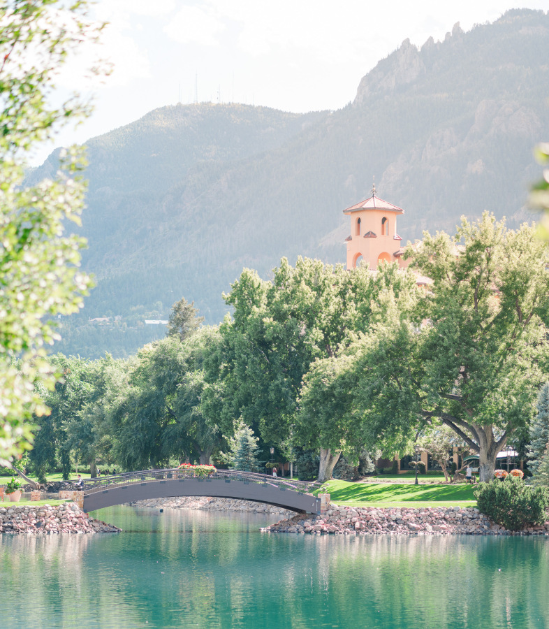 A look across a pond with a bridge under a Colorado Springs wedding venues
