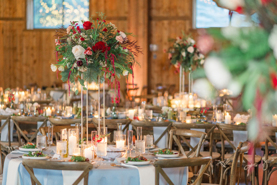 Details of a beautiful spruce mountain ranch wedding reception set up with tall red flower centerpieces