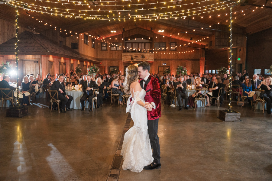 Newlyweds share a first dance during their spruce mountain ranch wedding reception under market lights